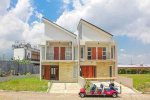 a small red car parked in front of a house at TwoSpaces Living at Panorama Villas in Batu