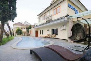 a swimming pool in front of a house at TwoSpaces Living at Panorama Villas in Batu