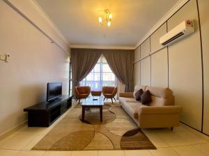 a living room with a couch and a tv at Sumai Hotel Apartment in Kuala Terengganu