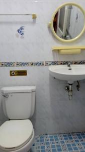 a bathroom with a white toilet and a sink at Baan Nakarin Guest House บ้านนครินทร์ in Patong Beach