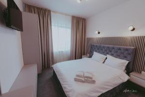 ein Schlafzimmer mit einem Bett mit zwei Schuhen drauf in der Unterkunft Pensiunea Belvedere in Ranca