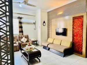 ein Wohnzimmer mit einem Sofa und einem TV in der Unterkunft Impressa on Shah in Dhaka