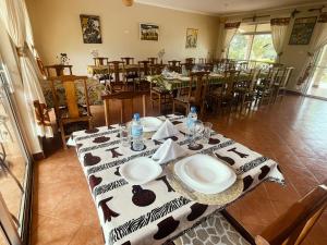 ein Esszimmer mit einem Tisch mit Tellern darauf in der Unterkunft Maktau Mountain Lodge in Kirongo