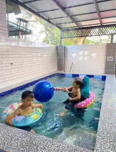 twee jonge jongens spelen in een zwembad bij Homestay Kuala Kangsar Private Pool in Kuala Kangsar
