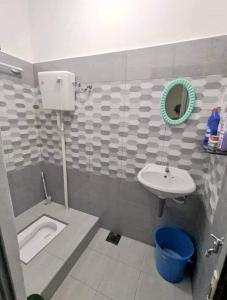 een badkamer met een wastafel, een toilet en een spiegel bij Homestay Kuala Kangsar Private Pool in Kuala Kangsar