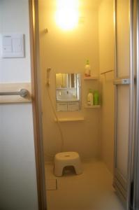 a bathroom with a toilet with a light on the wall at Vegan Minshuku Sanbiki Neko in Kyoto