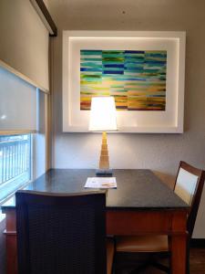 a lamp on a table with a painting on the wall at Baymont Inn and Suites by Wyndham Columbus / Near OSU in Columbus