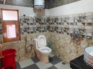 uma casa de banho com um WC e um lavatório em Kavya Home Stay em Chachyot