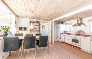 uma cozinha com um tecto de madeira e uma mesa e cadeiras em Paradis em Hasle