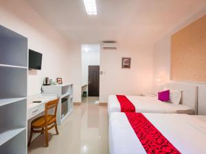 a hotel room with two beds and a desk at Kesari Glory Nusa Penida by Pramana Villas in Nusa Penida