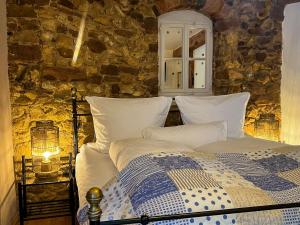 a bedroom with a bed and a stone wall at Hotel Zum Burggraf in Neuleiningen +95 photos