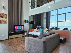 ein Wohnzimmer mit einem Sofa und einem TV in der Unterkunft Duplex Seaview Comfort Stay in City By IZ in George Town