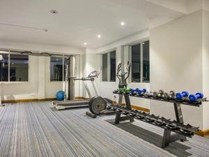 a fitness room with a gym with a bench and weights at Sarah Resort Gazipur in Rājābāri