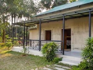 a small house with a balcony in a yard at Sarah Resort Gazipur in Rājābāri