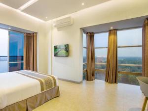 1 dormitorio con 1 cama y ventanas grandes en Sarah Resort Gazipur en Rājābāri