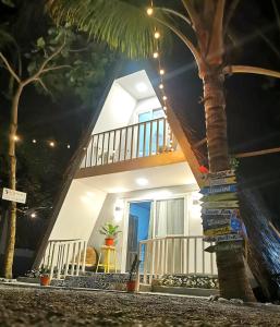 a house with a balcony and a palm tree at Hidden View Resort GovGen 