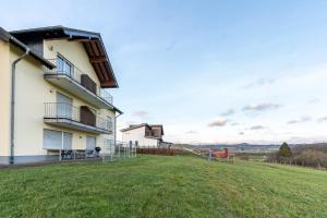 a house with a large yard with a swing at Ferienwohnung Linda in Kelberg