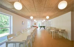 an empty room with white tables and chairs at Eight-Bedroom Holiday Home In Glesborg in Glesborg
