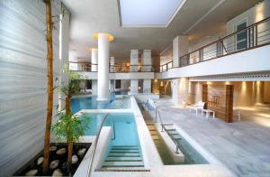 an indoor pool in a building with stairs and tables at Royal Hideaway Sancti Petri in Chiclana de la Frontera