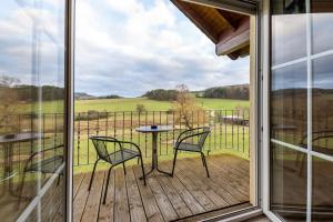 a balcony with a table and chairs on a deck at Ferienwohnung Linda in Kelberg +4 photos