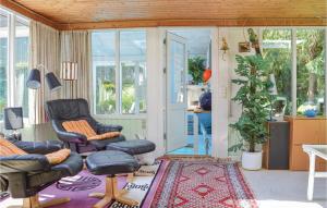 ein Wohnzimmer mit 2 Stühlen und einem Teppich in der Unterkunft Beautiful Home In Gilleleje With Private Swimming Pool, Can Be Inside Or Outside in Gilleleje