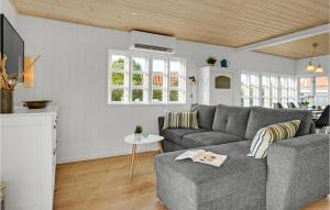 uma sala de estar com um sofá cinzento e uma mesa em Amazing Home In Juelsminde With Wifi em Sønderby