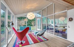 a living room with a red chair and a rug at Amazing Home In Hjslev With Kitchen in Højslev