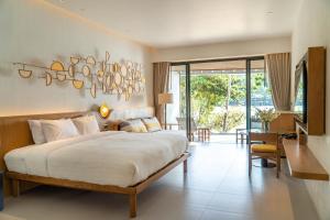 a bedroom with a large bed and a living room at SYLVAN Koh Chang in Ko Chang