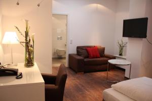 a living room with a couch and a tv at Hotel Restaurant Schwan in Wertheim