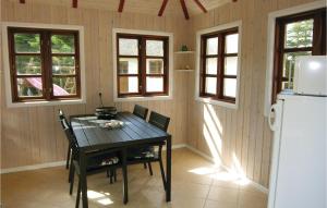 a kitchen with a table and a refrigerator at Three-Bedroom Holiday Home In Bagenkop in Bagenkop