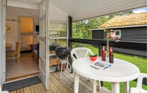 a tiny house with a patio and a table at 2 Bedroom Amazing Home In Nexø in Neksø