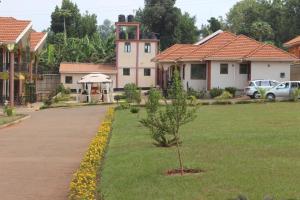 ein Haus mit einem Baum in der Mitte eines Gartens in der Unterkunft Signature Hotel Apartments in Jinja