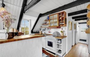 a large kitchen with white appliances and wooden cabinets at Holiday Home Havklitvej Ringkøbing Vi in Ringkøbing