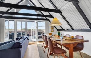 a living room with a table and a couch at Holiday Home Havklitvej Ringkøbing Vi in Ringkøbing