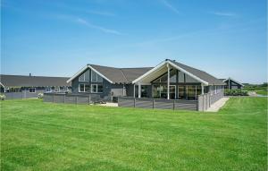 a house with a green lawn in front of it at Beach Front Home In Bogense With Sauna in Bogense