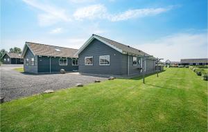 a house with a grass yard in front of it at Beach Front Home In Bogense With Sauna in Bogense +25 photos