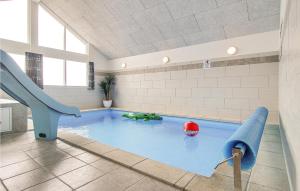 ボーゲンセにあるAwesome Home In Bogense With 7 Bedrooms, Wifi And Indoor Swimming Poolの建物内の滑り台付きスイミングプール