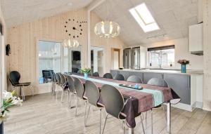 a long dining room with a long table and chairs at Awesome Home In Bogense With 7 Bedrooms, Wifi And Indoor Swimming Pool in Bogense