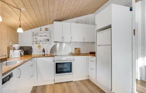 Biała kuchnia z białymi urządzeniami i drewnianym sufitem w obiekcie Cozy Home In Rm With Kitchen w mieście Bolilmark