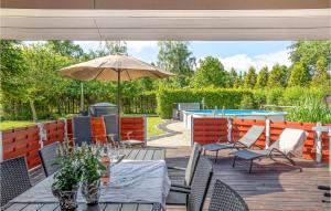 un patio con sombrilla, mesas y sillas en Amazing Home In rsted With Outdoor Swimming Pool, en Ørsted