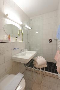 a white bathroom with a sink and a toilet at Hotel Tirolerhof in Leutasch