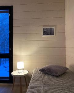 a bedroom with a bed and a table and a chair at Tammikon Tupa in Tuusula