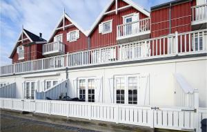 ein großes rotweißes Gebäude mit einem weißen Zaun in der Unterkunft Pet Friendly Apartment In Bagenkop With Harbor View in Bagenkop