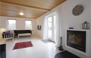 a living room with a flat screen tv and a couch at Cozy Home In stermarie With Kitchen in Østermarie