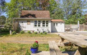 a small white shed with a picnic table and a bench at Nice Home In Nex With Wifi in Neksø