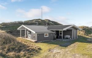 een klein huis bovenop een heuvel bij Stunning Home In Fan With House A Panoramic View in Fanø