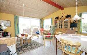 a living room with a table and chairs at Nice Home In Hvide Sande With House A Panoramic View in Havrvig