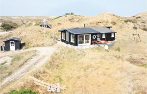 a black house on top of a hill at Nice Home In Hvide Sande With House A Panoramic View in Havrvig