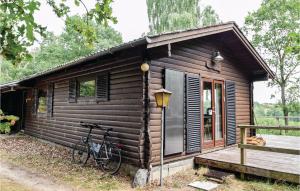 een fiets geparkeerd buiten een houten hut bij Cozy Home In Ejstrupholm With Kitchen in Ejstrup