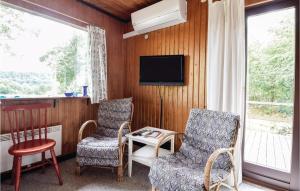 een woonkamer met 2 stoelen en een televisie bij Cozy Home In Ejstrupholm With Kitchen in Ejstrup
